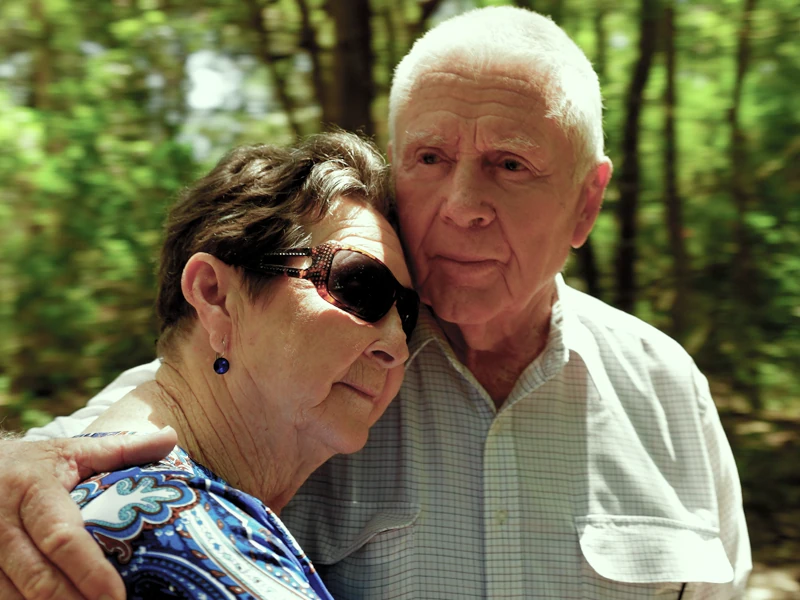 An older man kssing his wife